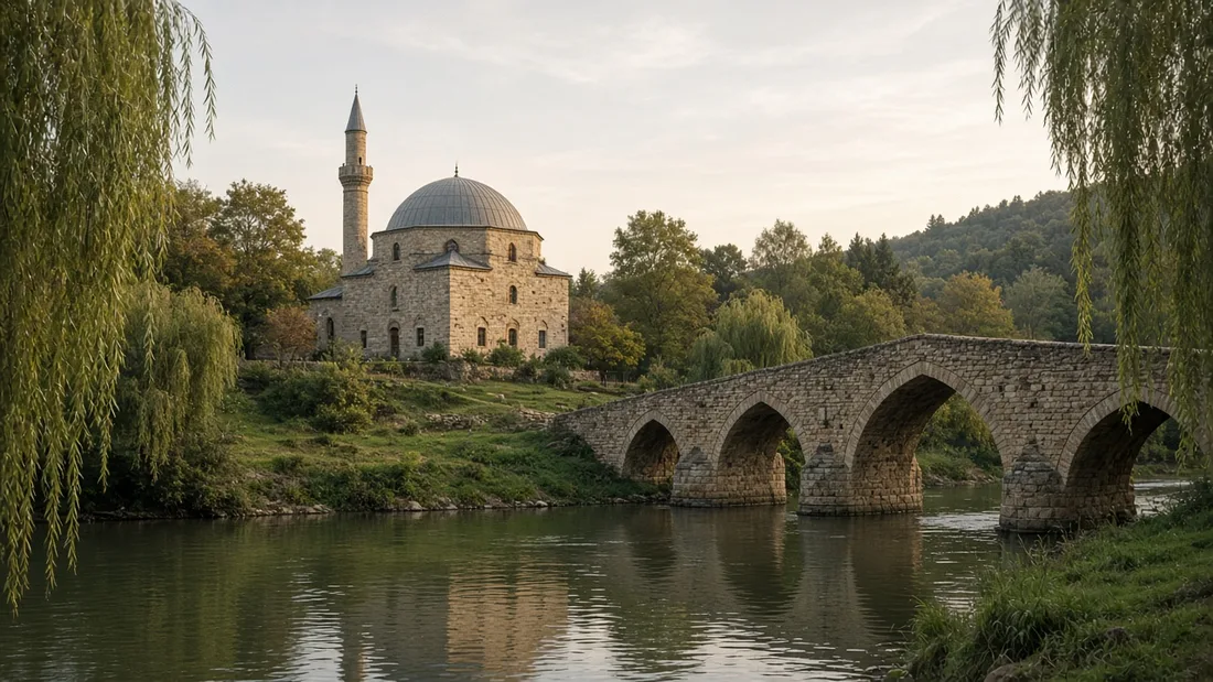 Nehir kıyısında tek kubbeli küçük bir taş cami ve önünden geçen sivri kemerli eski taş köprü, yumuşak ikindi ışığı